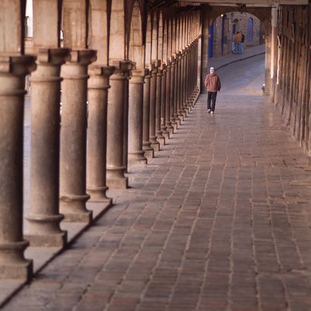 Cusco Peru, Man walking down arched hallwayの写真素材