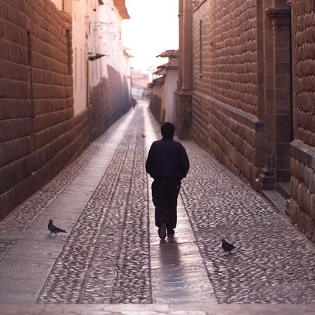 Cusco Peru, Man walking down narrow streetの写真素材
