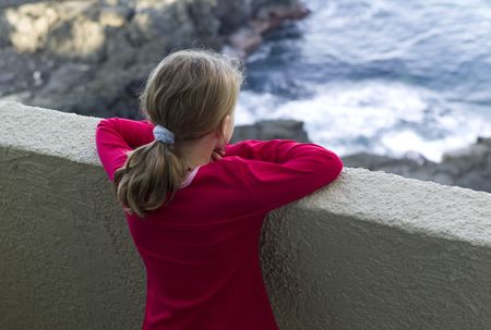 Girl looking over wallの写真素材