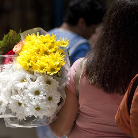 Back view of a woman carrying bouquets of flowers in San Jose Costa Ricaの写真素材