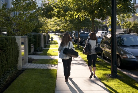 Two women walking on a sidewalk in Vancouver, British Columbia, Canadaの写真素材