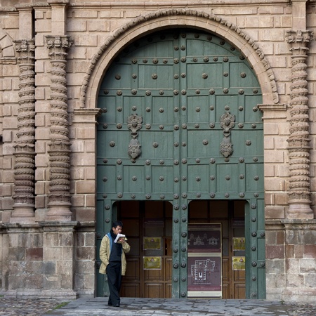 Man reading a book in front of a church, Plaza de Armas, Cuzco, Peru
