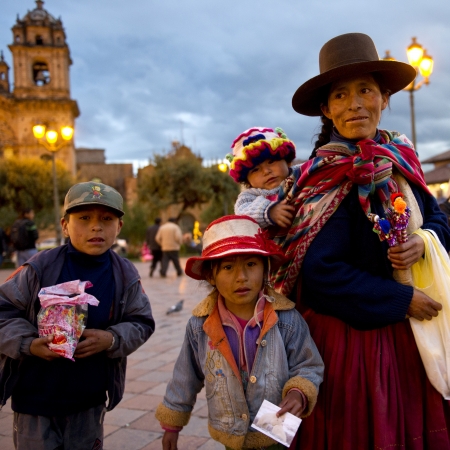 Woman with her children at a town square with Iglesia de la Compania in the background, Plaza de Armas, Cuzco, Peruの写真素材