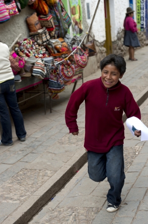Boy running at Sunday market, Pisac, Cuzco, Peruのeditorial素材