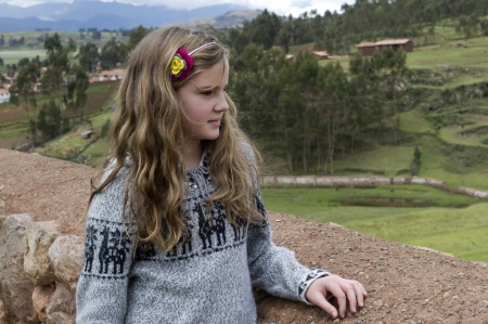 Girl standing on a roof and looking at view, Chinchero, Sacred Valley, Cusco Region, Peruのeditorial素材