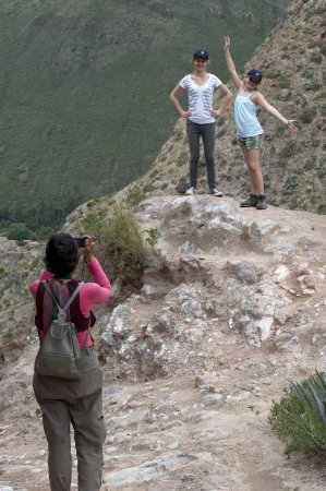 Woman taking picture of her friends with a camera in Sacred Valley, Cusco Region, Peruのeditorial素材