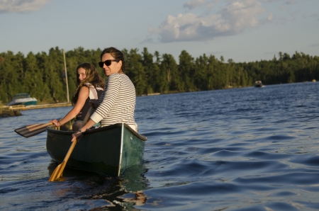 Woman rowing a boat with her daughter, Lake of The Woods, Keewatin, Ontario, Canadaのeditorial素材