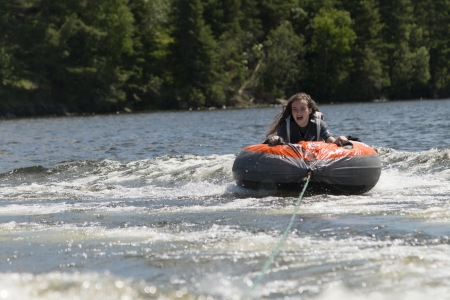 Girl enjoying on an inflatable raft, Lake of The Woods, Keewatin, Ontario, Canada