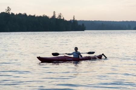 Woman kayaking in a lake, Lake of The Woods, Keewatin, Ontario, Canadaのeditorial素材