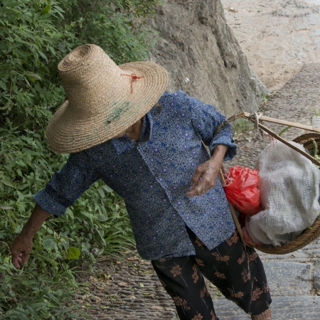 Close-up of a man holding a basket, Fuli Village, Yangshuo, Guilin, Guangxi Province, Chinaの写真素材