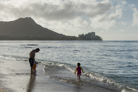 Man with his children on the beach, Waikiki, Honolulu, Oahu, Hawaii, USAのeditorial素材
