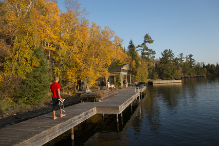 Man walking on a boardwalk, Kenora, Lake of The Woods, Ontario, Canadaのeditorial素材