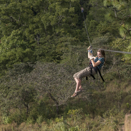 Girl riding a zip line in a forest, Copan, Copan Ruinas, Copan Department, Honduras