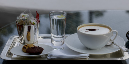 Close-up of Cappuccino with cookies and glass of water on a tray, Marrakesh, Moroccoのeditorial素材
