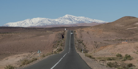 Road leading towards snowcapped mountains, Atlas Mountains, Moroccoの写真素材