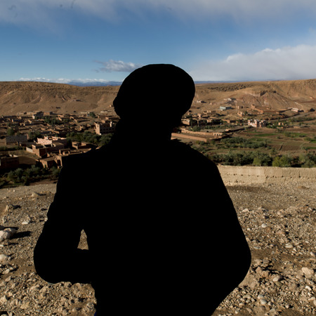Tuareg man looking at a town view from the terrace of a fort, Ait Benhaddou, Ouarzazate, Souss-Massa-Draa, Moroccoの写真素材