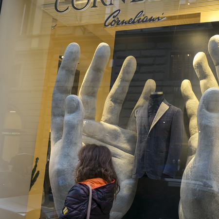 Woman walking by a clothing store window display, Florence, Tuscany, Italy