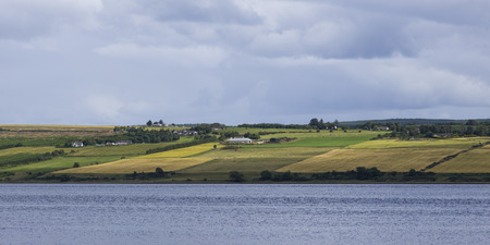 Scenic view of a small village at coast against cloudy sky, Dingwall, Scottish Highlands, Scotlandの写真素材