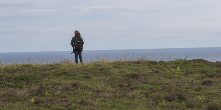 Rear view of a woman standing at coast, Duncansby Head, John o' Groats, Caithness, Scottish...