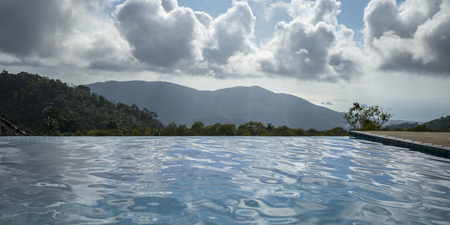 Swimming pool with mountains in background, Koh Samui, Surat Thani Province, Thailandの写真素材