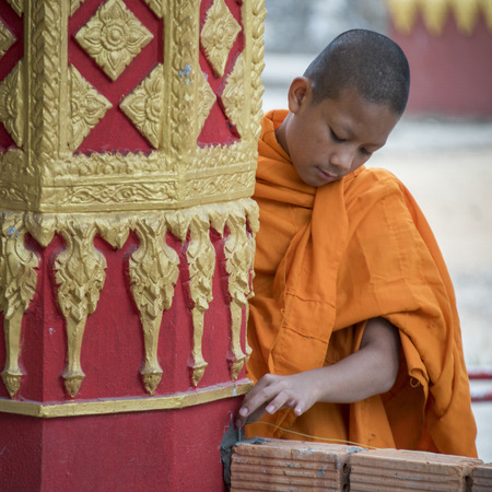 Boy monk standing outside temple, Luang Prabang, Laosのeditorial素材