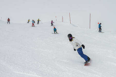 Tourists skiing and snowboarding on snowy mountain, Whistler, British Columbiaの写真素材