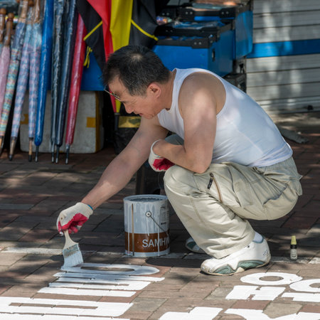 Sign writer working on roadside, Dongdaemun Market, Seoul, South Koreaのeditorial素材
