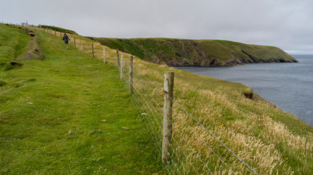 Woman walking along Erris Peninsula, Erris Head Loop Walk, Glenamoy, Belmullet, County Mayo, Irelandのeditorial素材