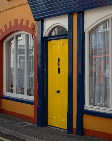 View of yellow store door and window along street, Kinsale, County Cork, Irelandのeditorial素材