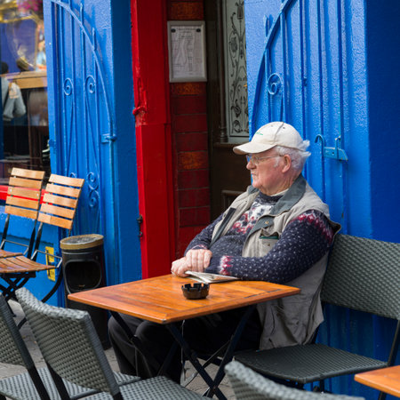 Elderly man sitting at patio restaurant, Galway City, County Galway, Republic of Irelandのeditorial素材