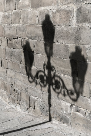 Shadow of lamp post against the stone wall, Ubeda, Jaen Province, Spainのeditorial素材