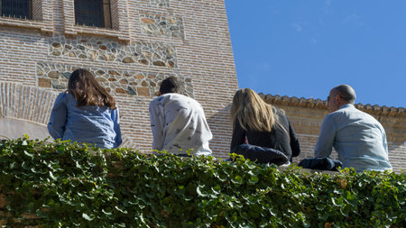 Back view of tourist sitting in a row in Alhambra, Granada, Granada Province, Spainのeditorial素材