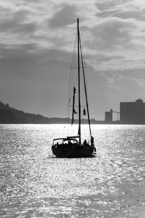 Silhouette of sailboat in river, Santa Maria de Belem, Lisbon, Portugalのeditorial素材