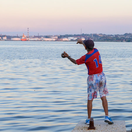 Rear view of a man fishing, Malecon, Havana, Cubaのeditorial素材