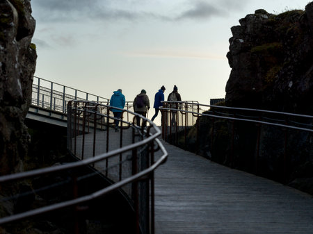 Tourists walking on boardwalk, Thingvellir National Park, Blaskogabyggd, Southern Region, Icelandのeditorial素材