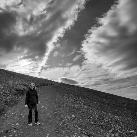 Woman on volcanic field under cloudy sky, Hverfjall crater, Skutustaoahreppur, Northeastern Region, Icelandのeditorial素材