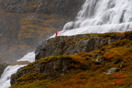 Tourist taking selfie with mobile phone at waterfall, Dynjandi Waterfall, Isafjordur, Westfjords,...