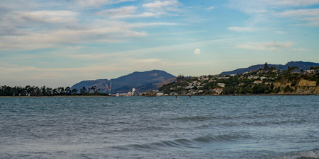 Nelson city seen from Tasman Bay with moon in the sky, Tahunanui Beach, South Island, New Zealandのeditorial素材