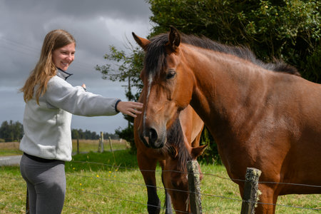 Woman touching a horse, West Coast, South Island, New Zealandのeditorial素材