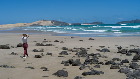 Woman walking on the beach, North Easternmost Tip, Aupouri Peninsula, Cape Reinga, North Island, New Zealandのeditorial素材