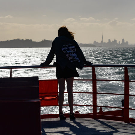 Woman standing along the railing of a boat, Half Moon Bay, Auckland Region, North Island, New Zealandのeditorial素材