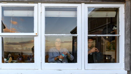 Woman looking out of window, Palm Beach, Waiheke Island, Auckland, Auckland Region, North Island, New Zealandのeditorial素材