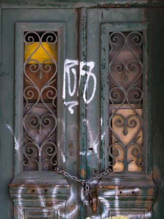 Graffiti on a chained exterior door in Athens, Greeceのeditorial素材