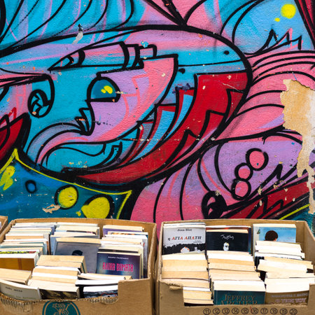 Boxes of books in front of a cartoon illustration painted on a wallのeditorial素材