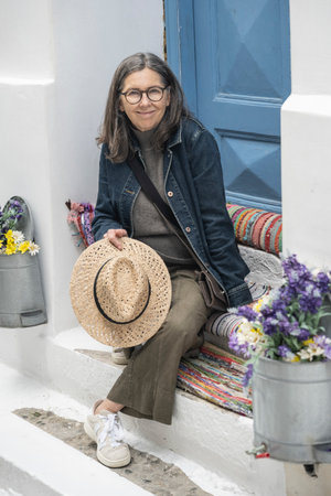Female tourist sitting on a doorstep in Mykonos Greeceのeditorial素材