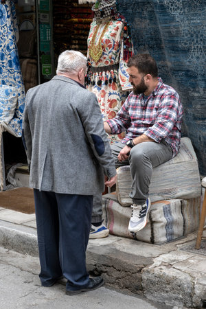 Two men having a conversation in front of a shop in Athens Greeceのeditorial素材