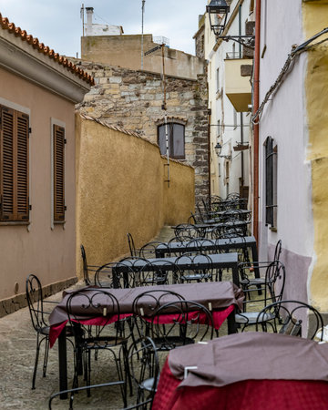 Tables and Chairs set up on a street outside a restaurant, Castelsardo, Northwest on the Sardinia...