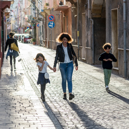Two women and two children walking on a street in Carloforte, San Pietro Island, South Sardina, Italyのeditorial素材
