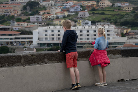Two children looking over a ledge, Castelsardo, Northwest on the Sardinia Island, Italyのeditorial素材