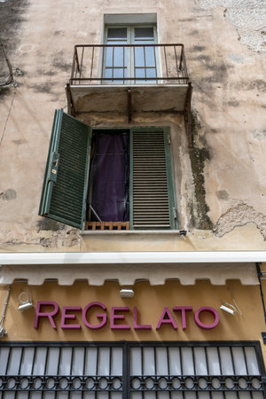 Sign on a bulding in the city of Alghero which is on the northwest coast of Sardinia, Italy.のeditorial素材